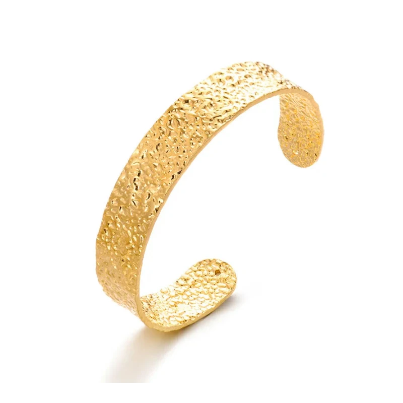 Bracelet jonc ouvert doré à la surface texturée . Forme large et légèrement incurvée  sans système de fermeture. 